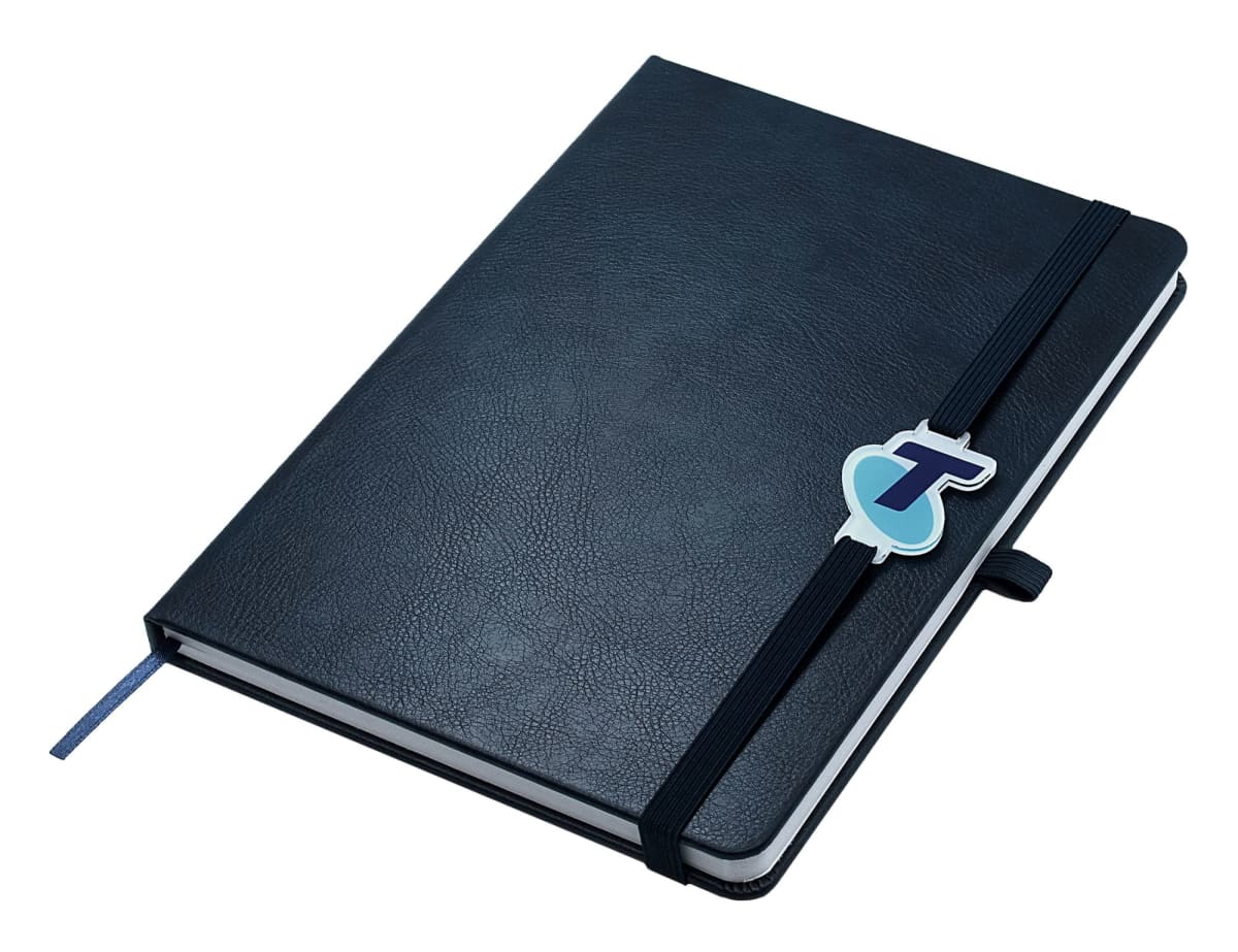 A closed black notebook with a black elastic strap, featuring a blue and purple logo on the strap. A blue ribbon bookmark is slightly visible at the edge. The notebook has a pen loop on the side.