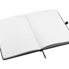 Open notebook with lined pages, black cover, and a black ribbon bookmark. Pages are dated at the top, and the notebook is laying flat.