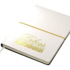 A white journal with a golden elastic band and gold lettering on the cover that reads Deboss The Premier Option. The journal is open slightly to reveal a ribbon bookmark.