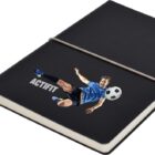 A black notebook with an elastic band features an image of a soccer player in blue kicking a ball. The word ACTIFIT is printed next to the player.