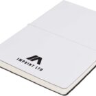 A white notebook with a thin elastic band wrapped around it and a ribbon bookmark. The cover features a black logo and the text IMPRINT LTD. The notebook is closed and laid flat on a white surface.