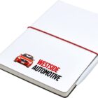 A white notebook with a red elastic band and a pen clipped to the side. The cover features an image of a red car and the text Westside Automotive.