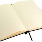 An open lined notebook with light-colored pages and a black ribbon bookmark lies flat. The notebook has a black pen attached to it.