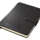 A black leather-bound notebook with a strap closure, embossed with the words The Premier Option. An attached black ribbon bookmark extends from the bottom. The notebook is closed, revealing only the outer cover.