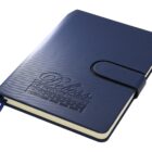 A blue leather-bound notebook with a strap closure and embossed text reading Dilass The Premier Option on the cover. It has a ribbon bookmark.