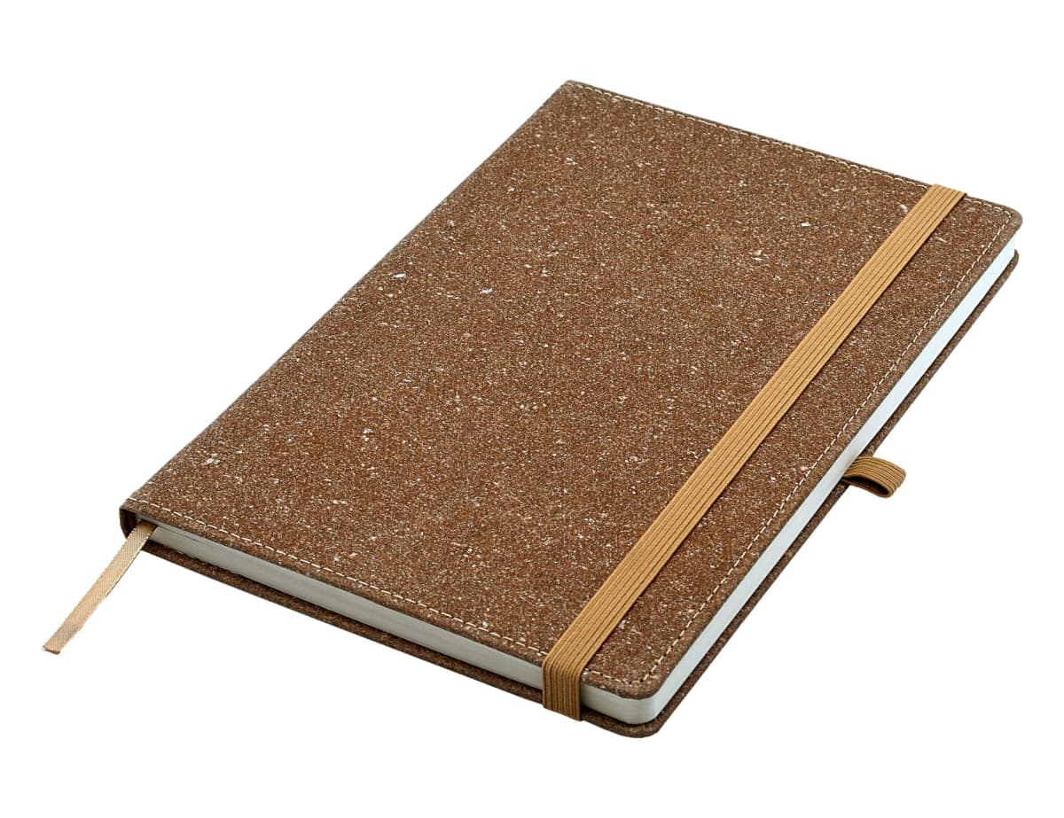 A brown speckled notebook with an elastic band closure and a ribbon bookmark.