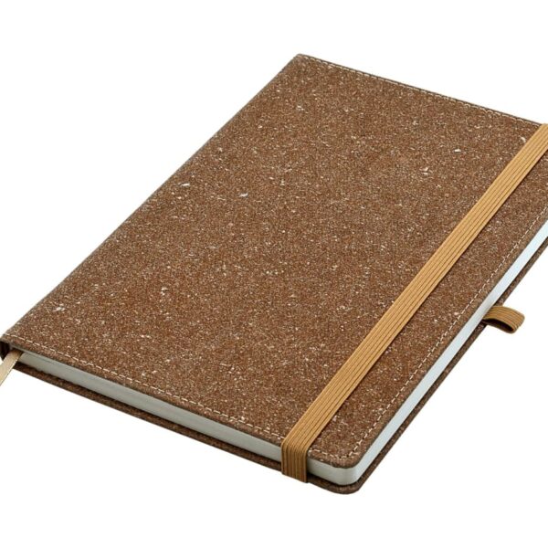 A closed, brown speckled notebook with an elastic band for closure lies on a flat surface. A beige pen loop is attached to the side, and a matching ribbon bookmark peeks out from the bottom.