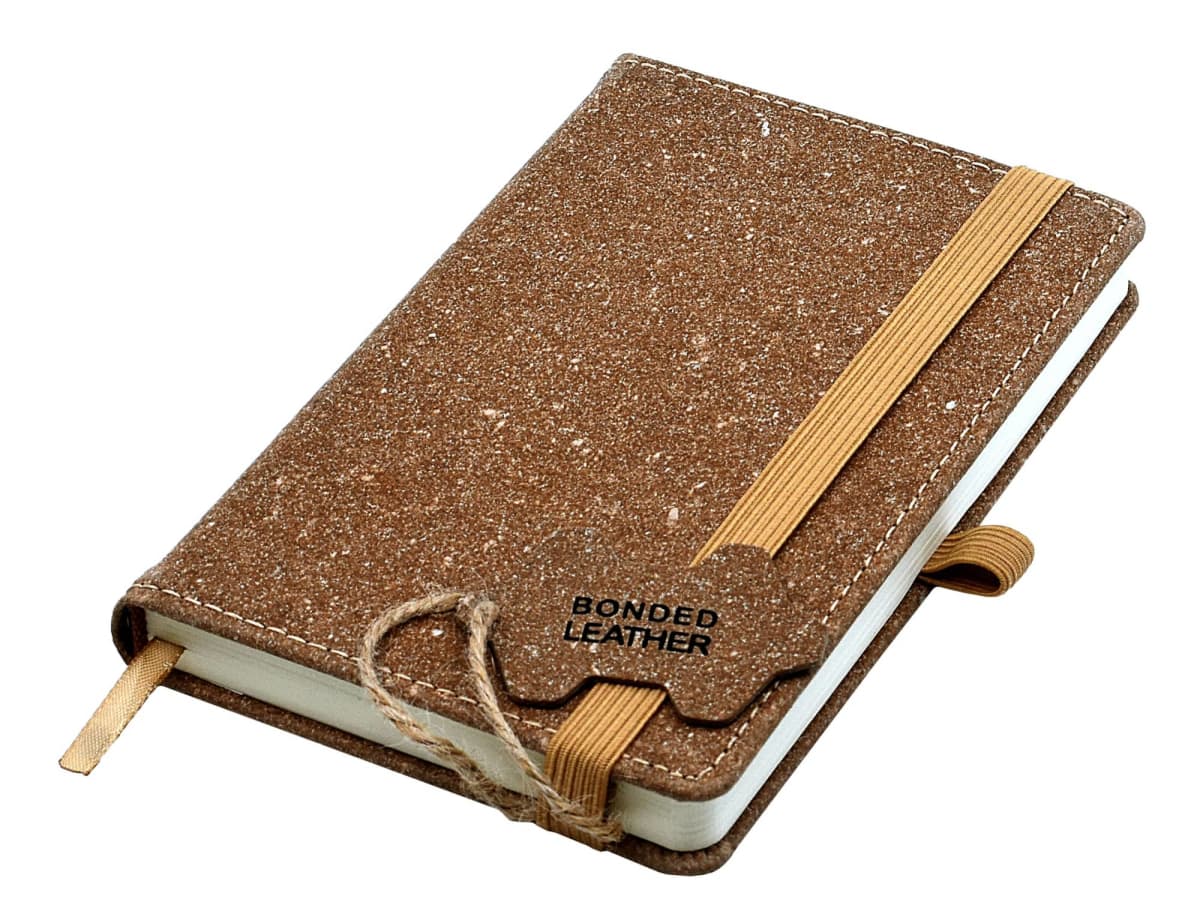 A brown textured notebook with a bonded leather cover and a tan elastic band closure. It features a pen loop and a bookmark ribbon.
