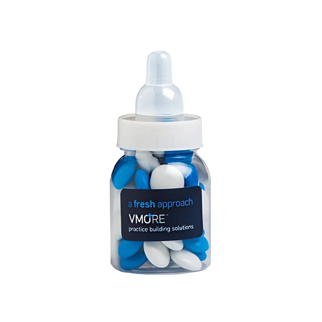The Logo Printed Bottle With Choc Beans is a clear baby bottle labeled a fresh approach and VMORE practice building solutions, filled with blue and white capsule-shaped objects, topped with a white cap and translucent nipple.