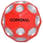 A red ball with multiple circular silver indents and the word COMDIAL printed in black across its center.