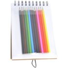 A spiral-bound notepad with a front pocket holding nine colored pencils arranged in a row. The colors include black, brown, green, blue, light blue, pink, orange, red, and yellow. The notepad is propped upright on a stand.