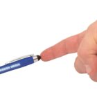 A close-up of a persons finger touching the tip of a blue stylus pen labeled Mission Media. The pen has a metallic clip and a black rubber stylus tip. The background is plain white.