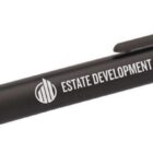 A black pen with a clip, featuring white text that reads Estate Development Co. and a logo.