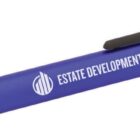 A blue and black ballpoint pen with Estate Development Co. printed in white along the side. The pen has a clip on the cap.