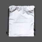 A white drawstring bag with black strings is centered against a gray background. The material appears slightly crinkled, with soft shadows creating a textured look.