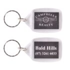 Two keychains with clear plastic frames. One keychain reads CAMPELLS REALTY, Family Owned Since 1970 and the other says Bald Hills, (07) 3261 6033. Both have metal rings attached.