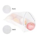 Mesh bag filled with peaches, shown from front and back with fabric texture details. The bag is white and partially open to reveal the fruit inside.