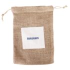 A burlap drawstring bag with a white square patch on the front displaying the word BRAUHAUS in blue text. The bag has a rustic appearance with tied strings at the top for securing the contents.