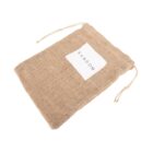 A burlap drawstring pouch lies flat on a white surface. The bag has a white square label with the word RANDOM printed in black capital letters.