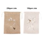 Two jute drawstring bags shown side by side. The left bag is 230gsm, with a bird and floral design. The right bag is 120gsm, featuring a similar floral motif with a bird. The 230gsm jute appears darker in color compared to the lighter 120gsm jute.