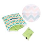 A reusable zippered bag with a colorful zigzag pattern holds several green tea bags. One tea bag is placed outside the bag. A zoomed-in circular inset shows the bags zigzag design in detail.