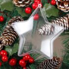 A transparent star-shaped ornament surrounded by pine cones, red berries, and green pine leaves, creating a festive holiday wreath display.