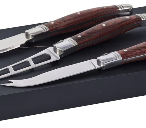 A set of three cheese knives with polished wooden handles is displayed on a black rectangular box. Each knife has a distinct blade style, including a spreader, a pronged narrow knife, and a soft cheese knife with cutouts.