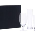 A black box alongside three different styles of clear drinking glasses: a goblet, a tall narrow glass, and a pint glass, all displayed against a white background.