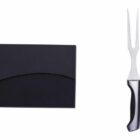 A black knife set box alongside three culinary tools: a carving fork, a chefs knife with a textured blade, and a sharpening rod. Each tool has a sleek, black and metallic design.