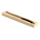 A folding knife with a black handle is displayed in an open wooden box.