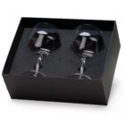 A black box containing two clear wine glasses. The glasses are securely placed in a fitted foam lining within the box.