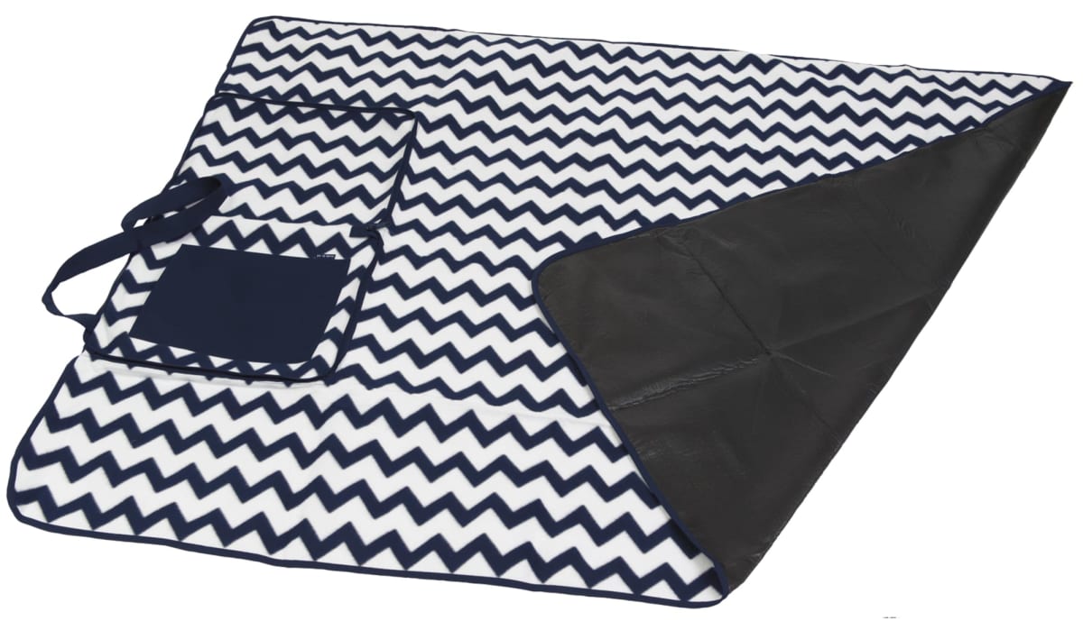 A picnic blanket with a black and white zigzag pattern and a solid black underside. It has an attached pocket and handle for easy carrying.