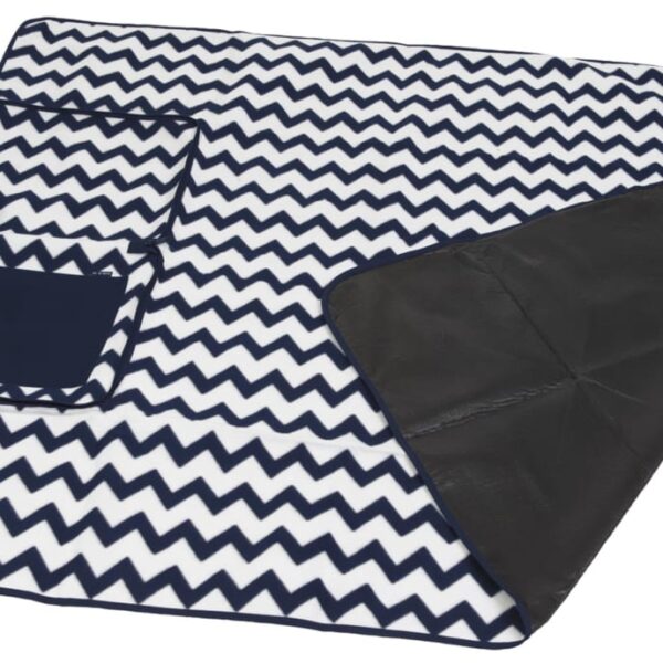 A folded picnic blanket with a black and white zigzag pattern. It has a black handle and a small pocket on one side, with a black waterproof backing visible underneath.