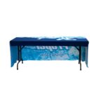 Table with a blue and white tablecloth featuring ice and water designs, displaying text fitness water. The tablecloth drapes over the table, partially covering the legs, with a clean white background.
