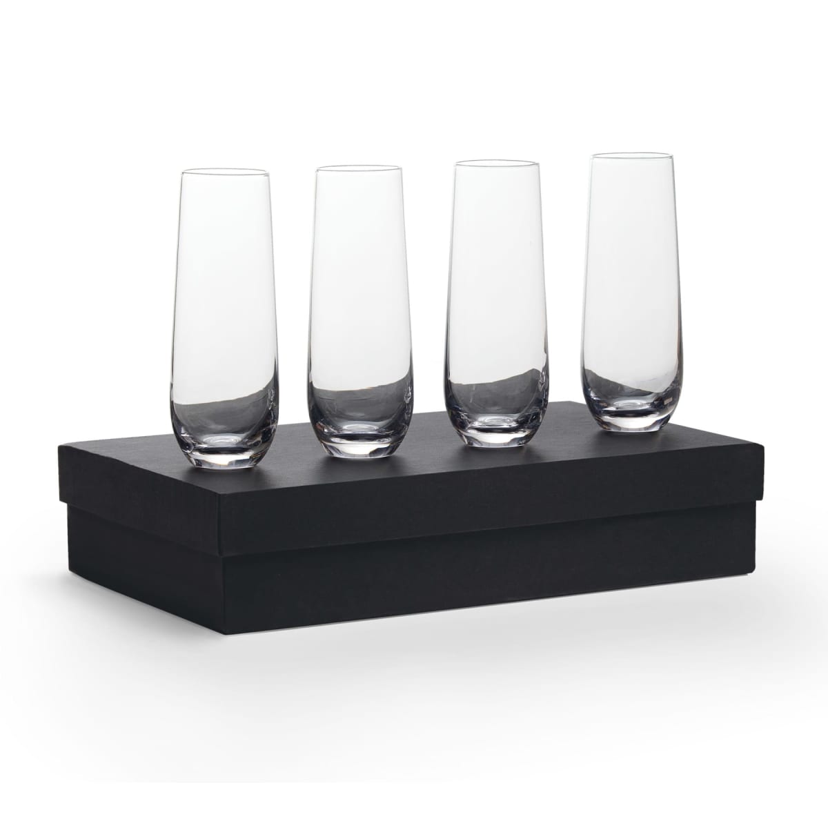 Four tall, clear glasses are neatly arranged on top of a closed black box, standing upright in a row. The glasses are sleek and elegant, with a modern design.