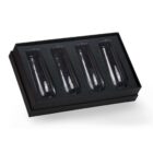 A set of four clear, empty champagne flutes neatly arranged in a black rectangular gift box with a foam insert. The box is open, showcasing the flutes.
