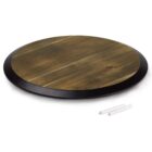A round wooden board with a black edge, accompanied by two pieces of white chalk, lying on a white background.