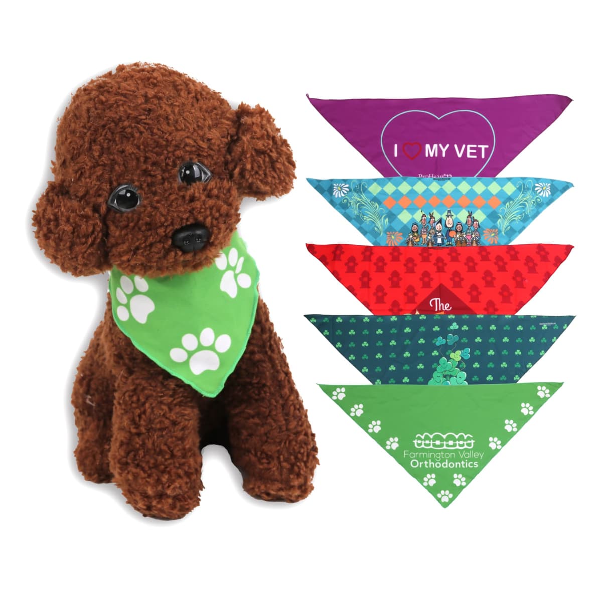 A plush brown dog with large eyes wears a green bandana with white paw prints. Beside it are five colorful pet bandanas: purple, blue with patterns, red with patterns, green with shamrocks, and green with white logos.
