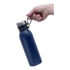 A hand with painted nails holds a blue water bottle with a silver cap by a black strap. The bottle is tilted slightly to the side against a plain white background.