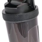 A hand holds a black shaker bottle by its loop handle. The bottle has a twist-off lid and a clear body.