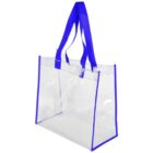 A clear tote bag with blue fabric handles and blue trim along the edges. The transparent design allows visibility of the bags contents.
