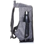 Side view of a gray fabric backpack with a black trim, featuring a black water bottle in its mesh side pocket. The backpack has adjustable shoulder straps and a top handle.