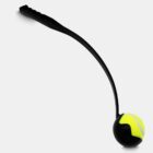 A black tennis ball launcher with a curved handle holding a yellow tennis ball at the tip, set against a white background.