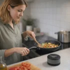 A woman cooks veggies with Timbre Speaker Wireless Chargers on the counter nearby.