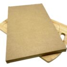 A rectangular cardboard sheet placed on top of two slightly visible wooden cutting boards with handles.