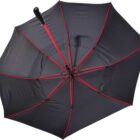 A black umbrella with red ribs is open, showing its structure. The handle is black and slightly curved. The umbrella is photographed against a white background.