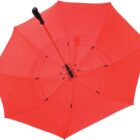 A red umbrella with a black handle is open, viewed from above. The fabric is slightly translucent, allowing some light to pass through, and the metal ribs are visible, supporting the canopy.