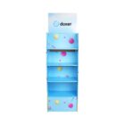 Blue display stand with four shelves, featuring colorful decorations like spheres and stripes. The top has a sign with the text doxer on it.