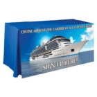 A table with a blue tablecloth featuring an image of a large cruise ship on the ocean. Text reads Cruise Around the Caribbean All Expenses Paid! and Sign Up Here!.