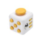 A white fidget cube with yellow buttons and a joystick on top. It features various tactile elements like buttons, dials, and a metallic ball on the sides.